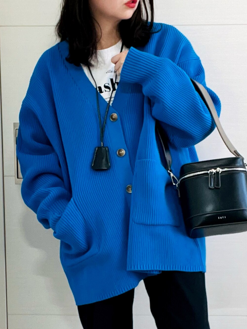 ブルー系のカーディガン/ボレロ、ホワイト系のTシャツ/カットソー、ブラック系のその他パンツを着用したレディースの冬コーディネートの3枚目の写真