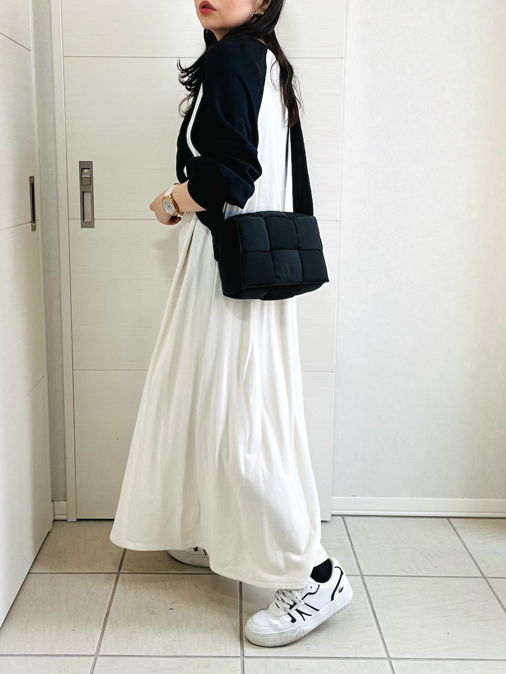 ホワイト系のワンピース、ホワイト系のスニーカー、ブラック系のショルダーバッグを着用したレディースの秋コーディネートの5枚目の写真