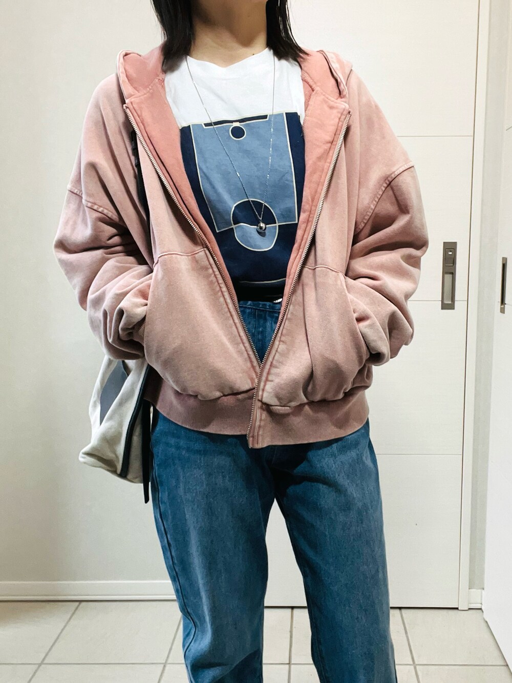 ブルー系のTシャツ/カットソー、ピンク系のパーカー、ブルー系のデニムパンツを着用したレディースの春コーディネートの2枚目の写真