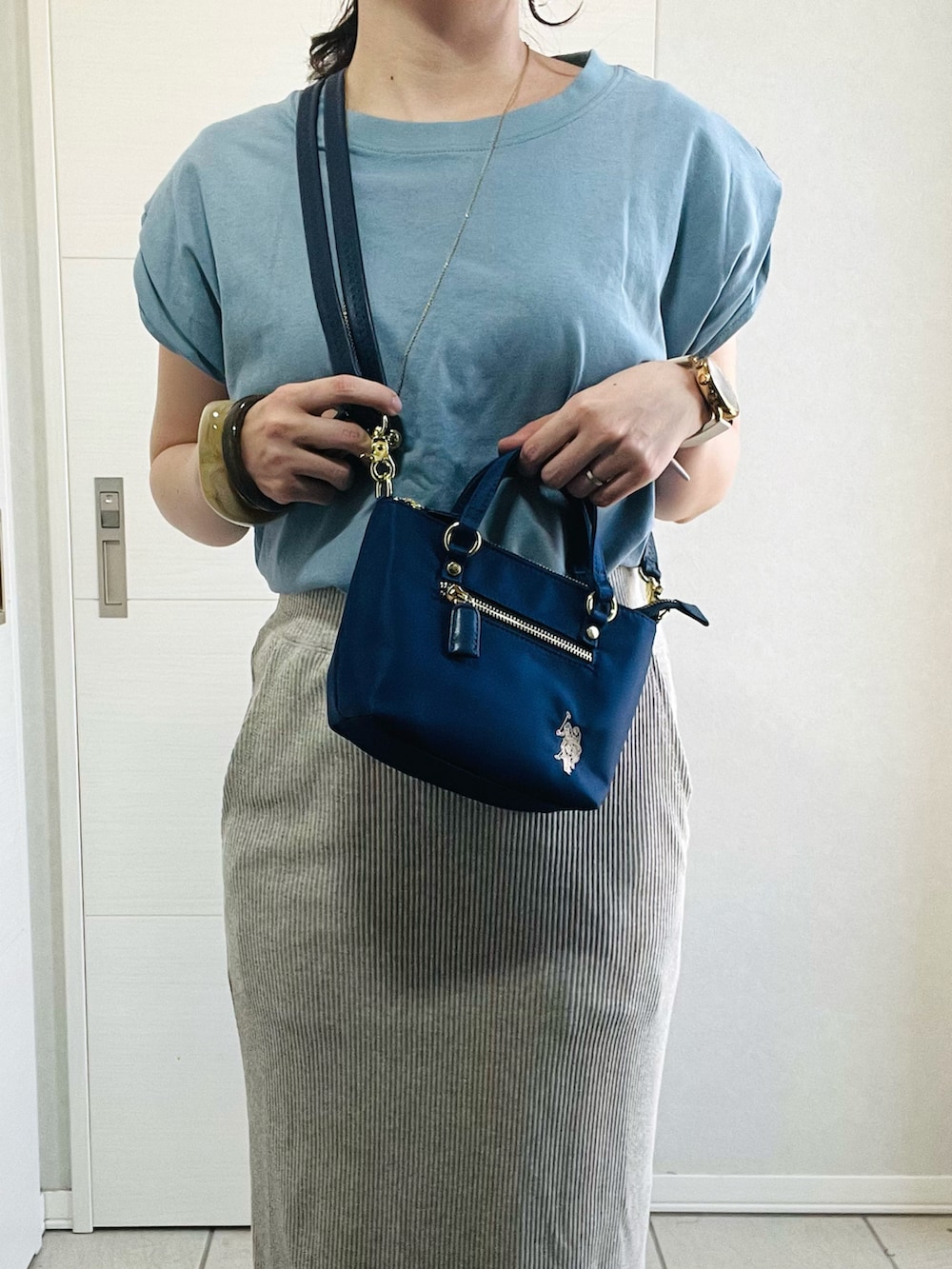 ブルー系のTシャツ/カットソー、ベージュ系のスカート、ホワイト系のスニーカーを着用したレディースの夏コーディネートの4枚目の写真