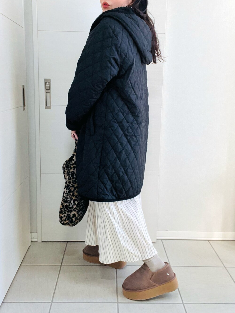 ブラック系のナイロンジャケット、ブルー系のワンピース、ベージュ系のスリッポンを着用したレディースの冬コーディネートの5枚目の写真