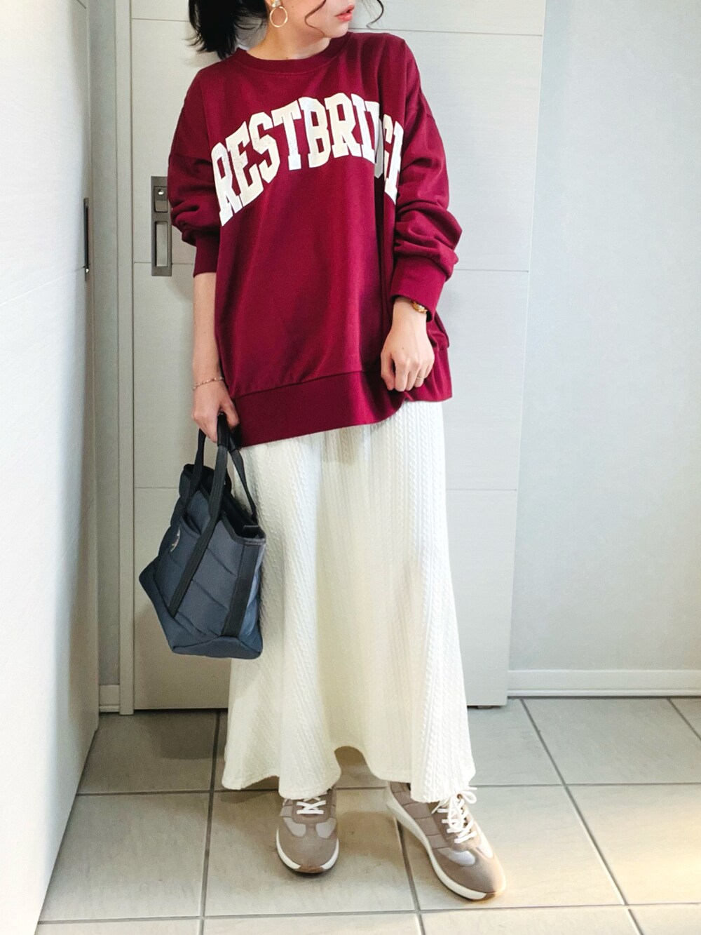 レッド系のTシャツ/カットソー、ホワイト系のスカート、ベージュ系のスニーカーを着用したレディースの秋コーディネートの3枚目の写真