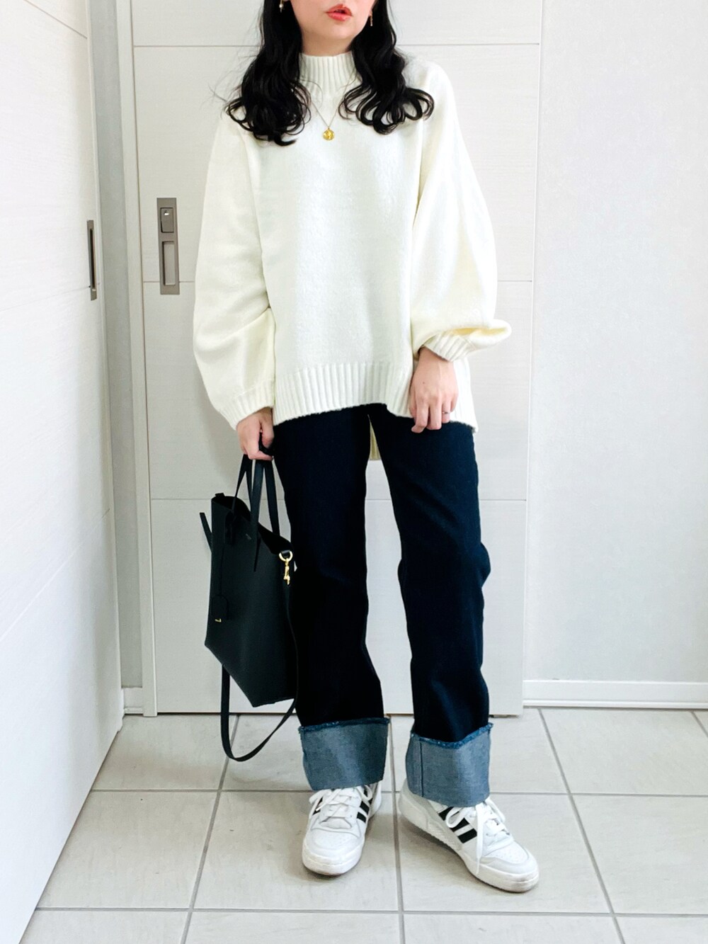 ホワイト系のニット/セーター、ブルー系のデニムパンツ、グレー系のスニーカーを着用したレディースの秋コーディネートの4枚目の写真