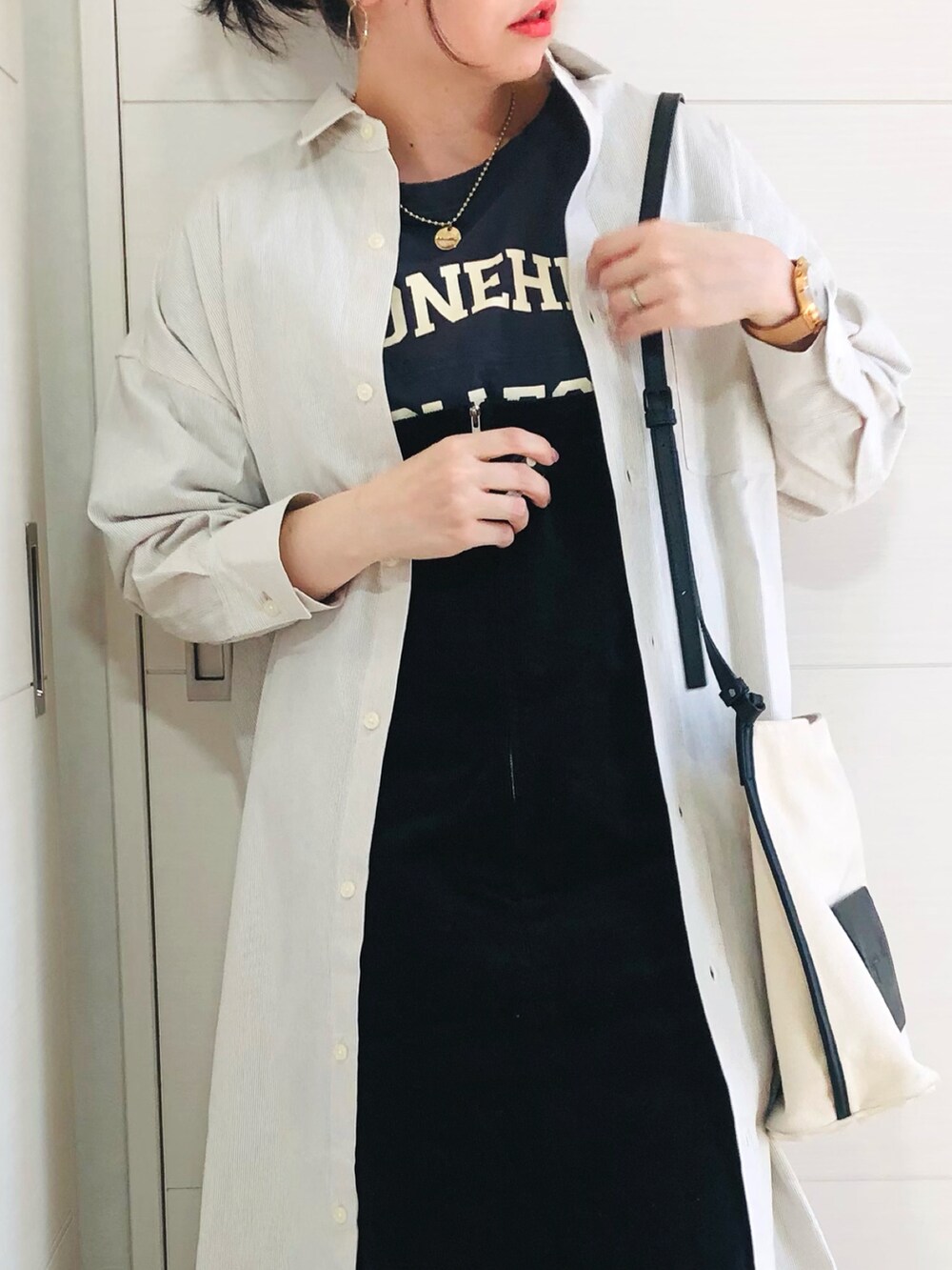 ベージュ系のワンピース、ブルー系のTシャツ/カットソー、ブラック系のジャンパースカートを着用したレディースの冬コーディネートの3枚目の写真