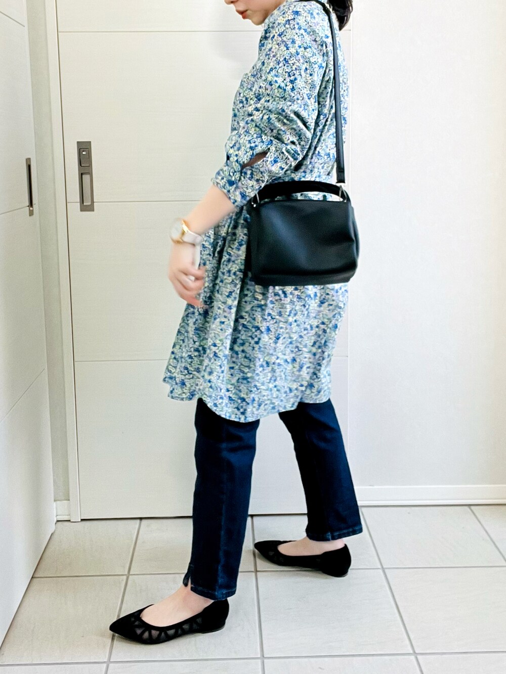 ブルー系のシャツワンピース、ブルー系のデニムパンツ、ブラック系のパンプスを着用したレディースの春コーディネートの3枚目の写真
