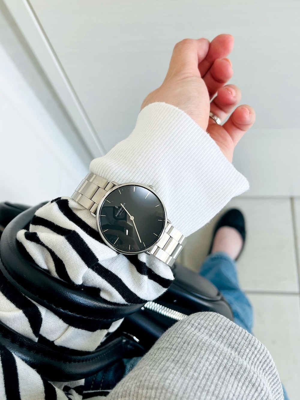 ブラック系のTシャツ/カットソー、グレー系のカーディガン/ボレロ、ブルー系のデニムパンツを着用したレディースの春コーディネートの3枚目の写真