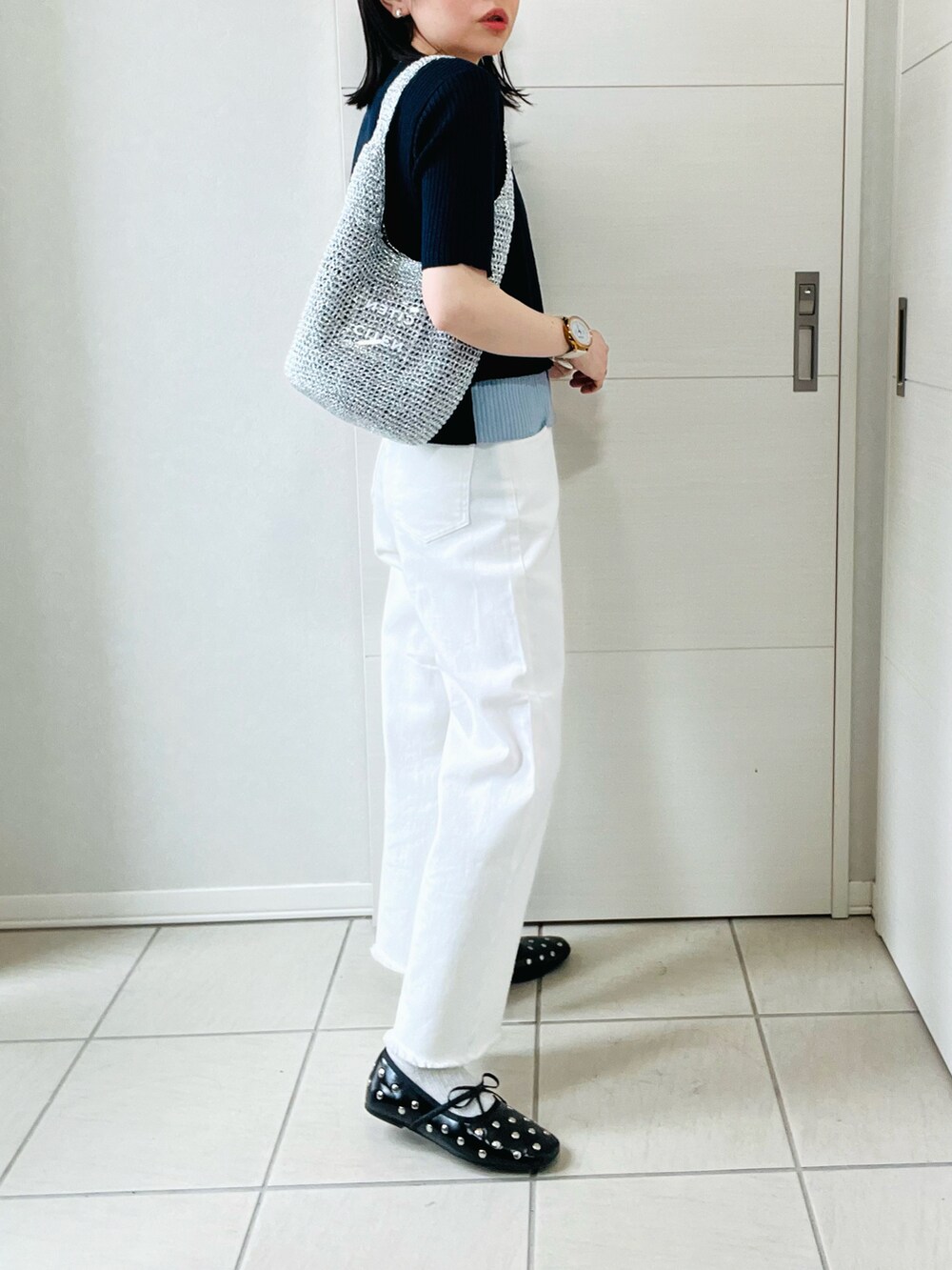ブルー系のニット/セーター、ホワイト系のデニムパンツ、ブラック系のバレエシューズを着用したレディースの春コーディネートの5枚目の写真