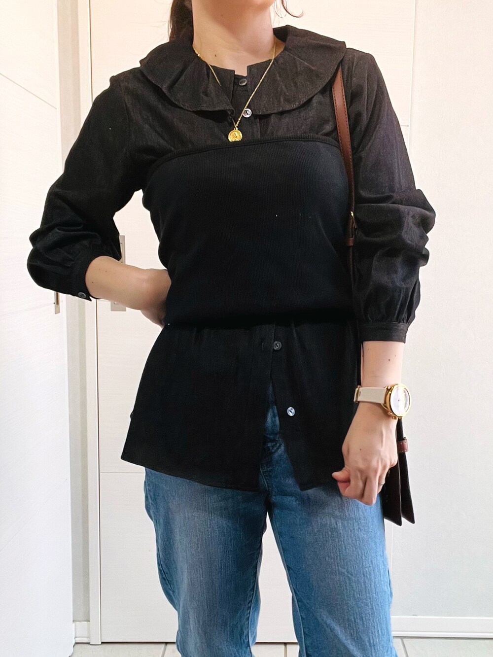 ブラック系のシャツ/ブラウス、ブラック系のベスト、ブルー系のデニムパンツを着用したレディースの春コーディネートの2枚目の写真