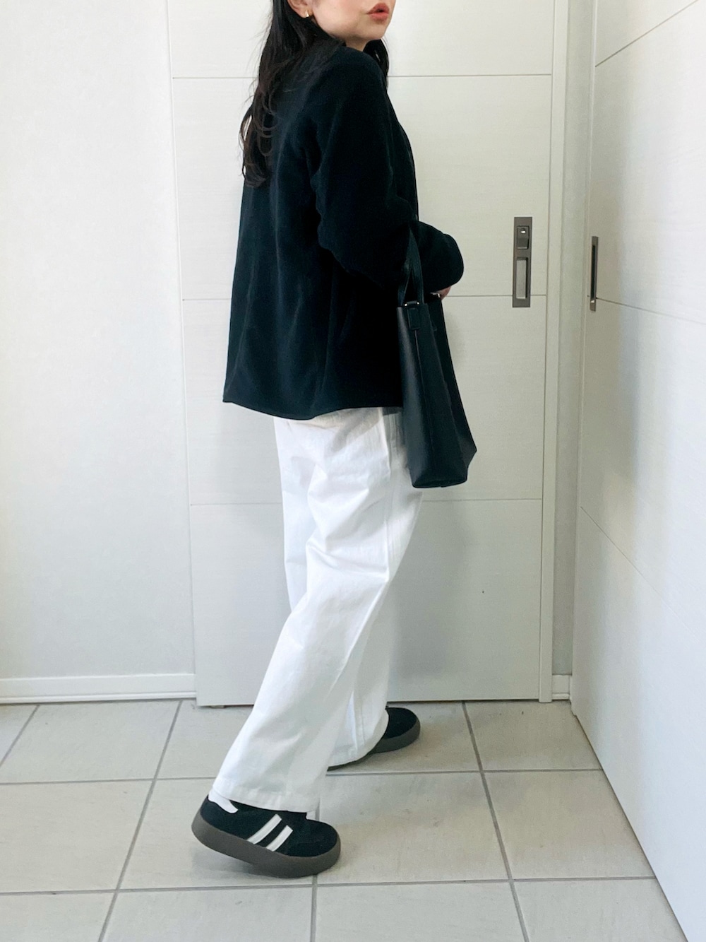 ブラック系のノーカラージャケット、グレー系のTシャツ/カットソー、ホワイト系のその他パンツを着用したレディースの秋コーディネートの5枚目の写真