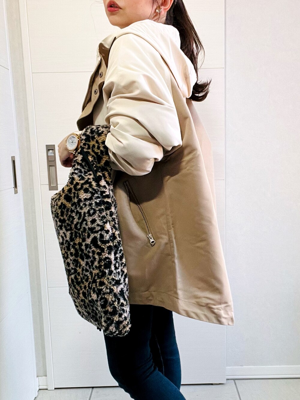 ベージュ系のマウンテンパーカー、ホワイト系のスウェット、ブルー系のデニムパンツを着用したレディースの秋コーディネートの3枚目の写真