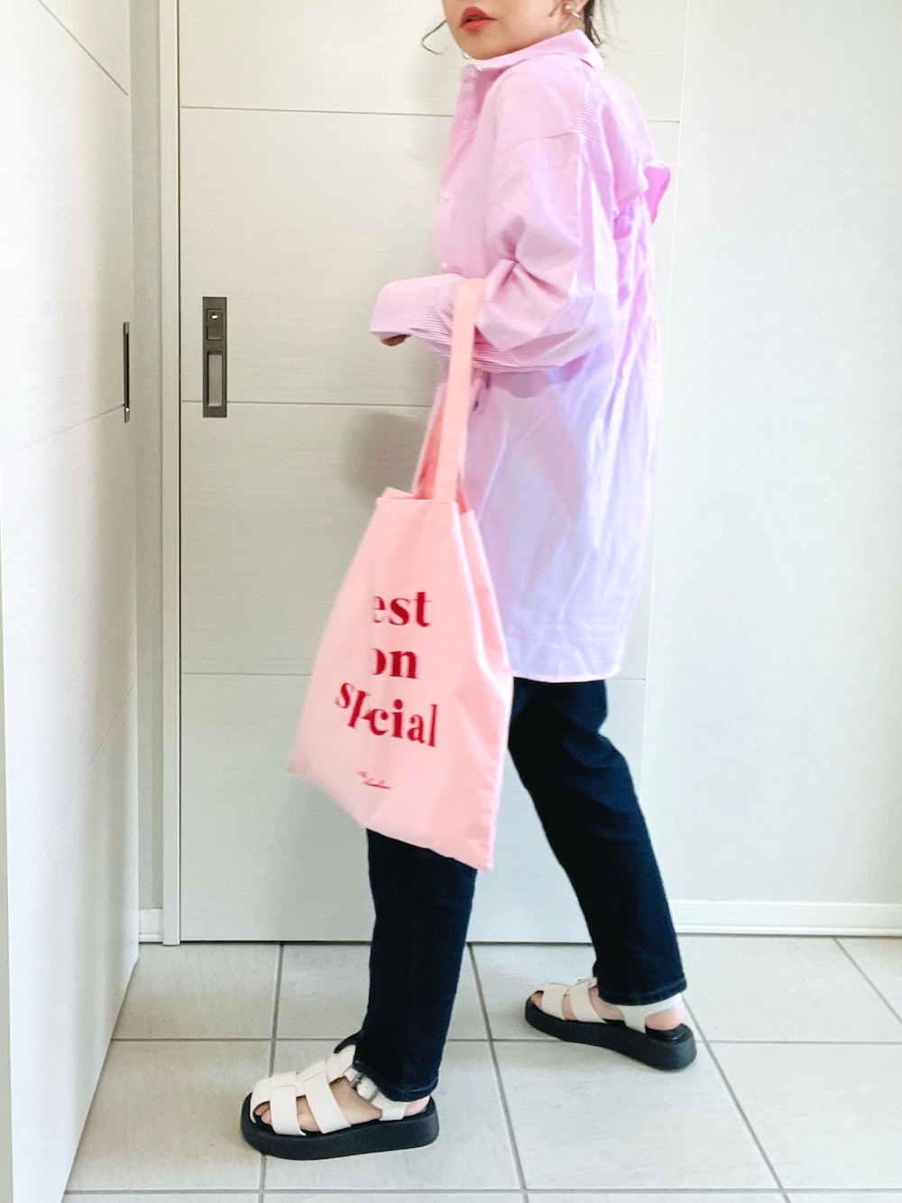 ピンク系のシャツ/ブラウス、ホワイト系のTシャツ/カットソー、ブルー系のデニムパンツを着用したレディースの春コーディネートの3枚目の写真