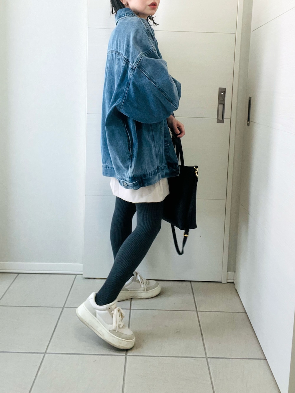 ブルー系のデニムジャケット、ベージュ系のニット/セーター、ホワイト系のスカートを着用したレディースの冬コーディネートの5枚目の写真