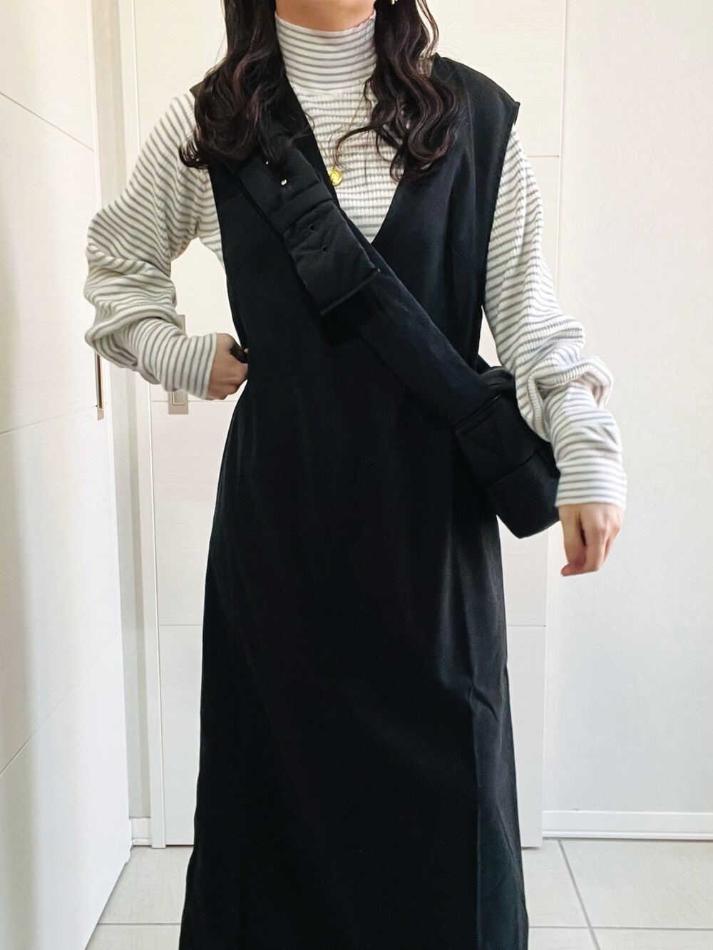 ブラック系のジャンパースカート、グレー系のニット/セーター、ブラック系のローファーを着用したレディースの秋コーディネートの3枚目の写真