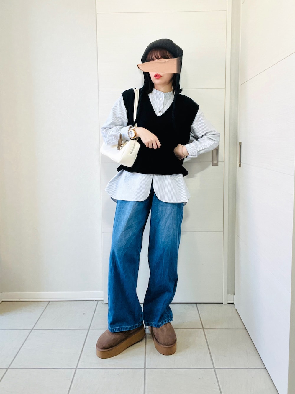 ブラック系のシャツ/ブラウス、ブルー系のデニムパンツ、ベージュ系のスリッポンを着用したレディースの秋コーディネートの4枚目の写真