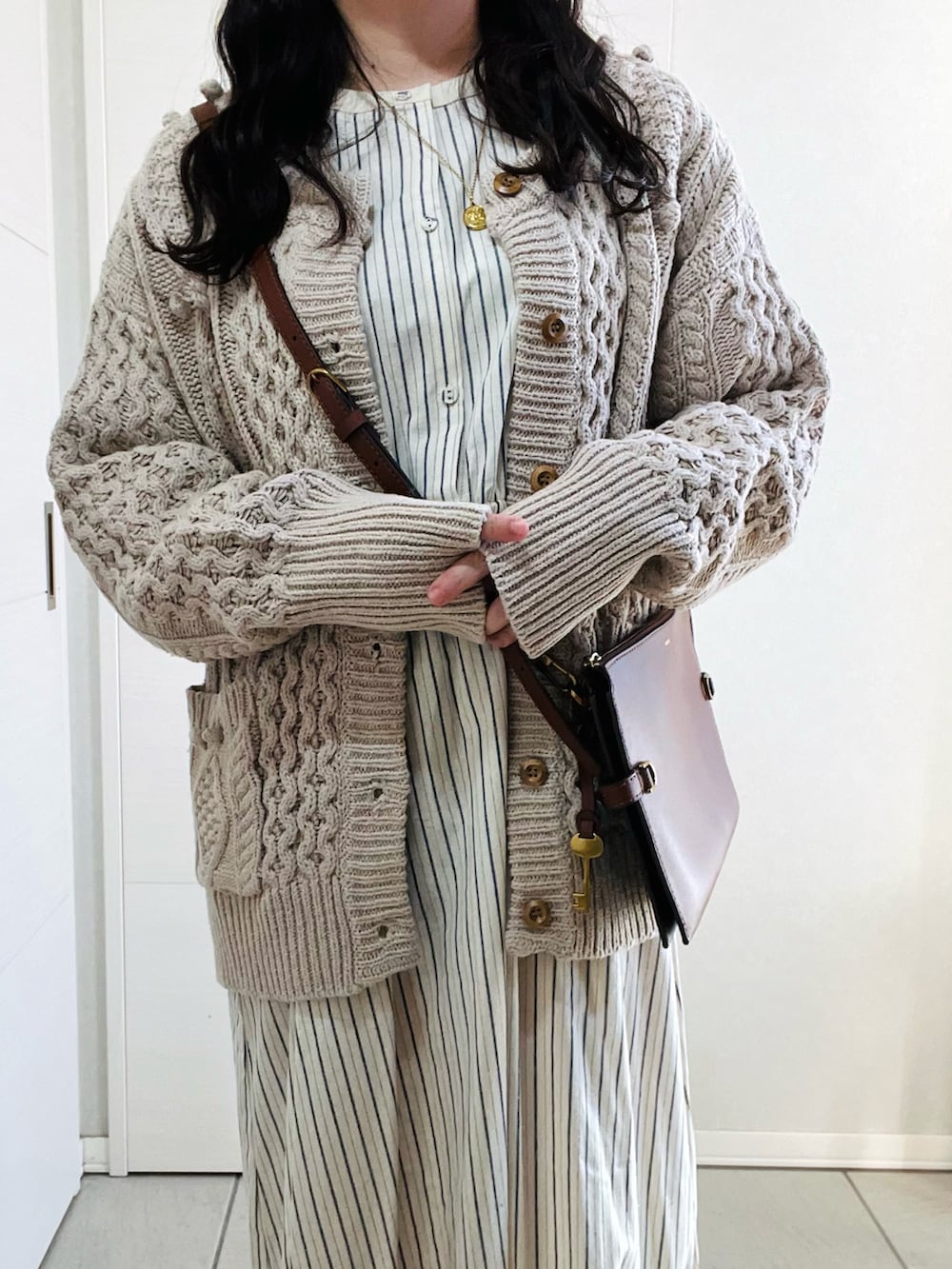 ベージュ系のカーディガン/ボレロ、ブルー系のワンピース、ベージュ系のスリッポンを着用したレディースの冬コーディネートの2枚目の写真