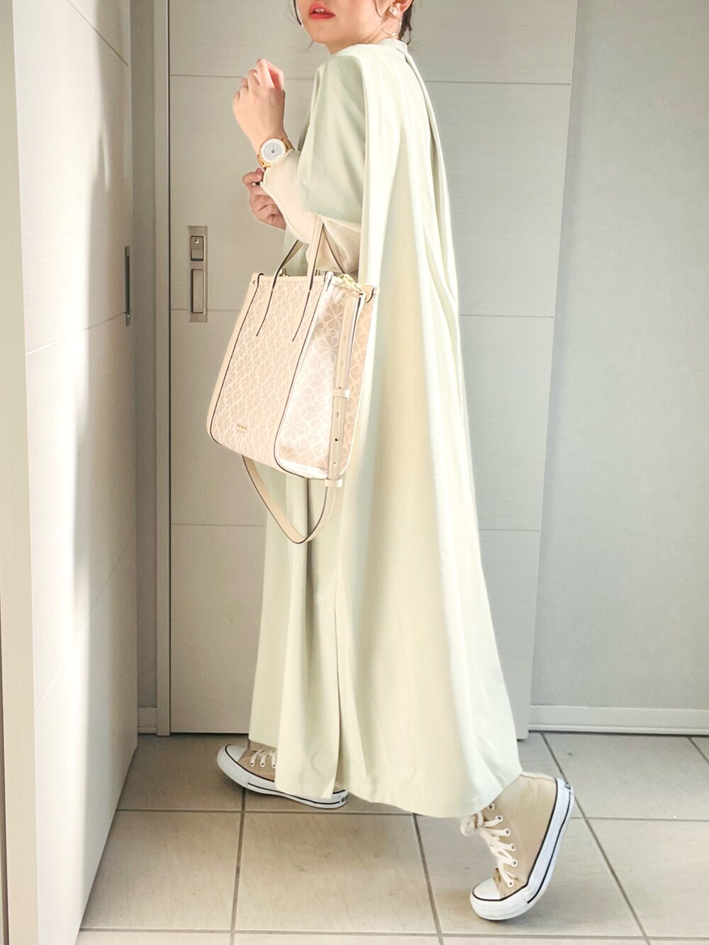 グリーン系のワンピース、その他のハンドバッグ、ベージュ系のスニーカーを着用したレディースの春コーディネートの3枚目の写真