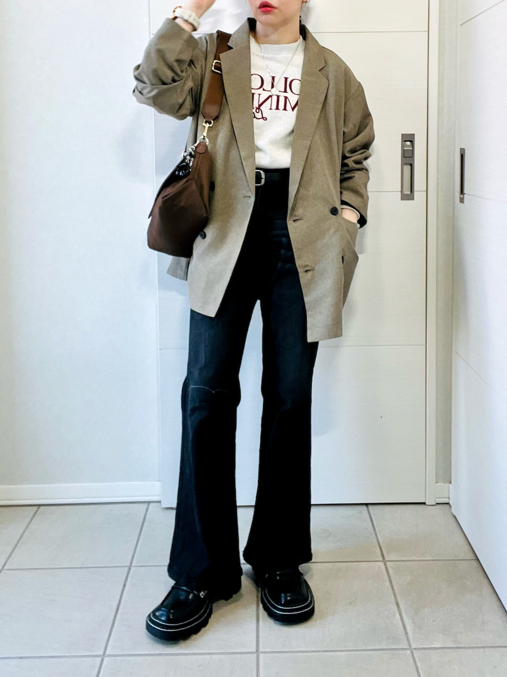 ベージュ系のテーラードジャケット、ベージュ系のスウェット、ブラック系のデニムパンツを着用したレディースの春コーディネートの4枚目の写真