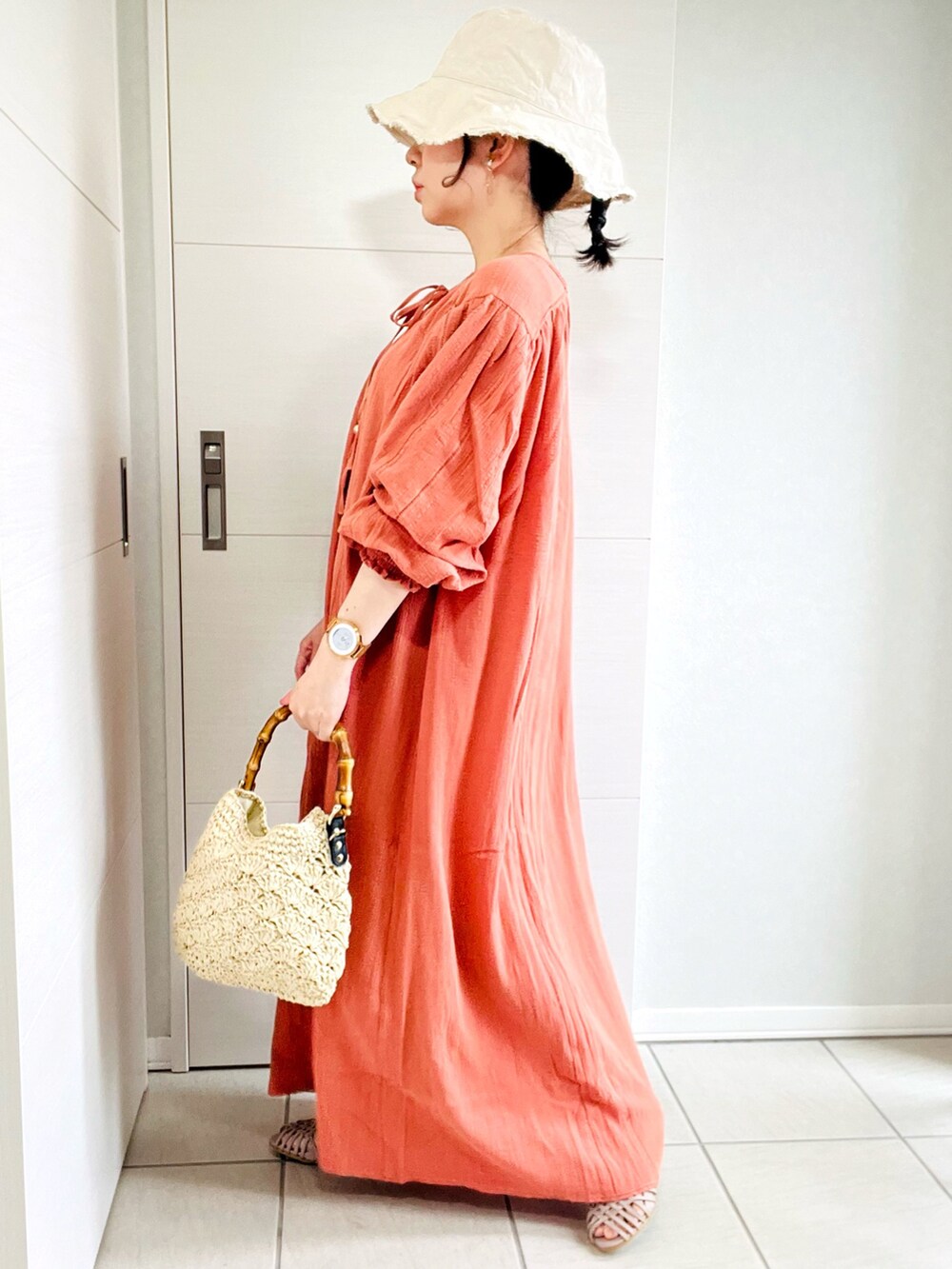 ピンク系のワンピース、グレー系のサンダル、ベージュ系のショルダーバッグを着用したレディースの夏コーディネートの3枚目の写真