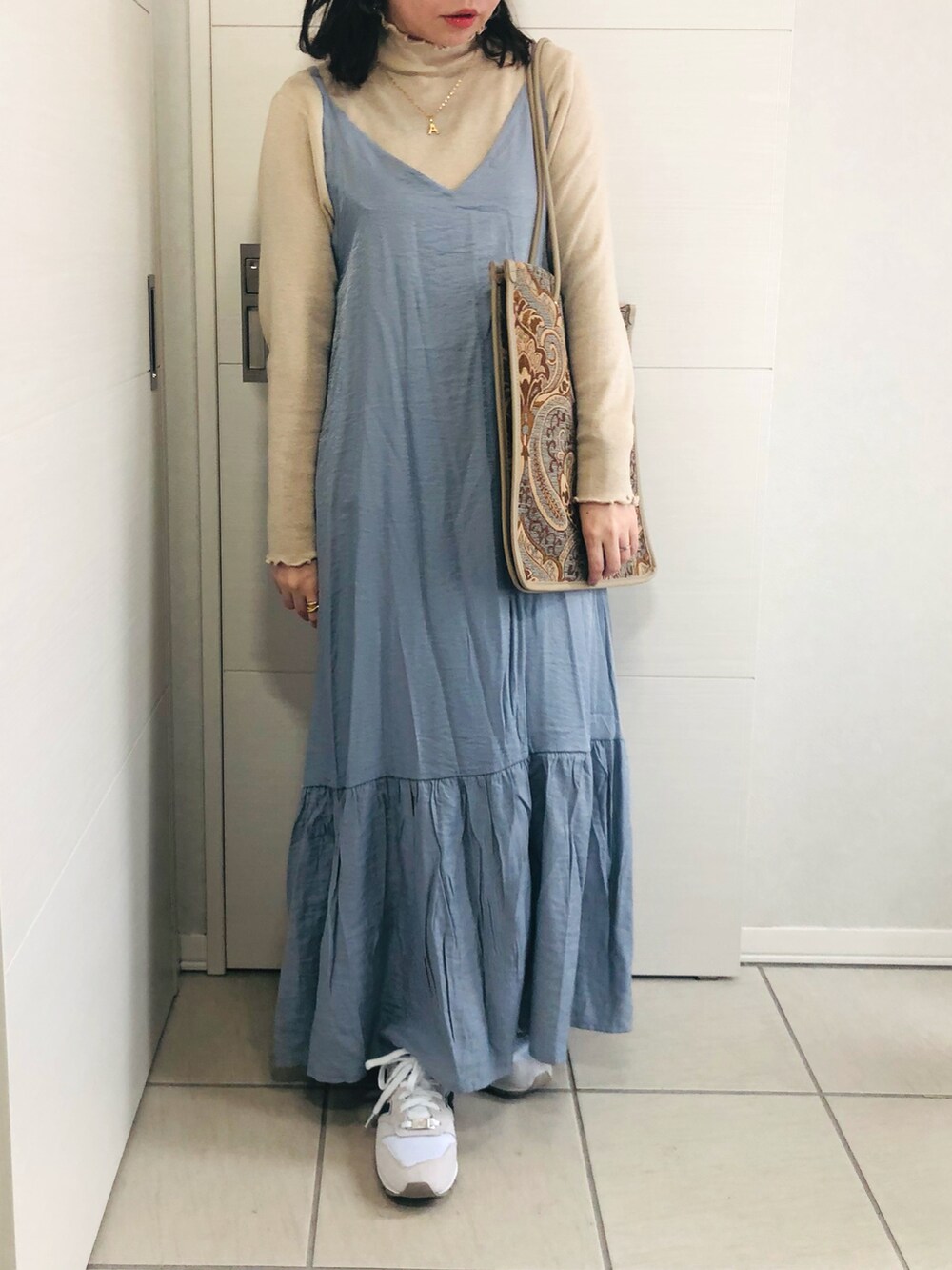 ブルー系のワンピース、ベージュ系のTシャツ/カットソー、ホワイト系のスニーカーを着用したレディースの秋コーディネートの2枚目の写真