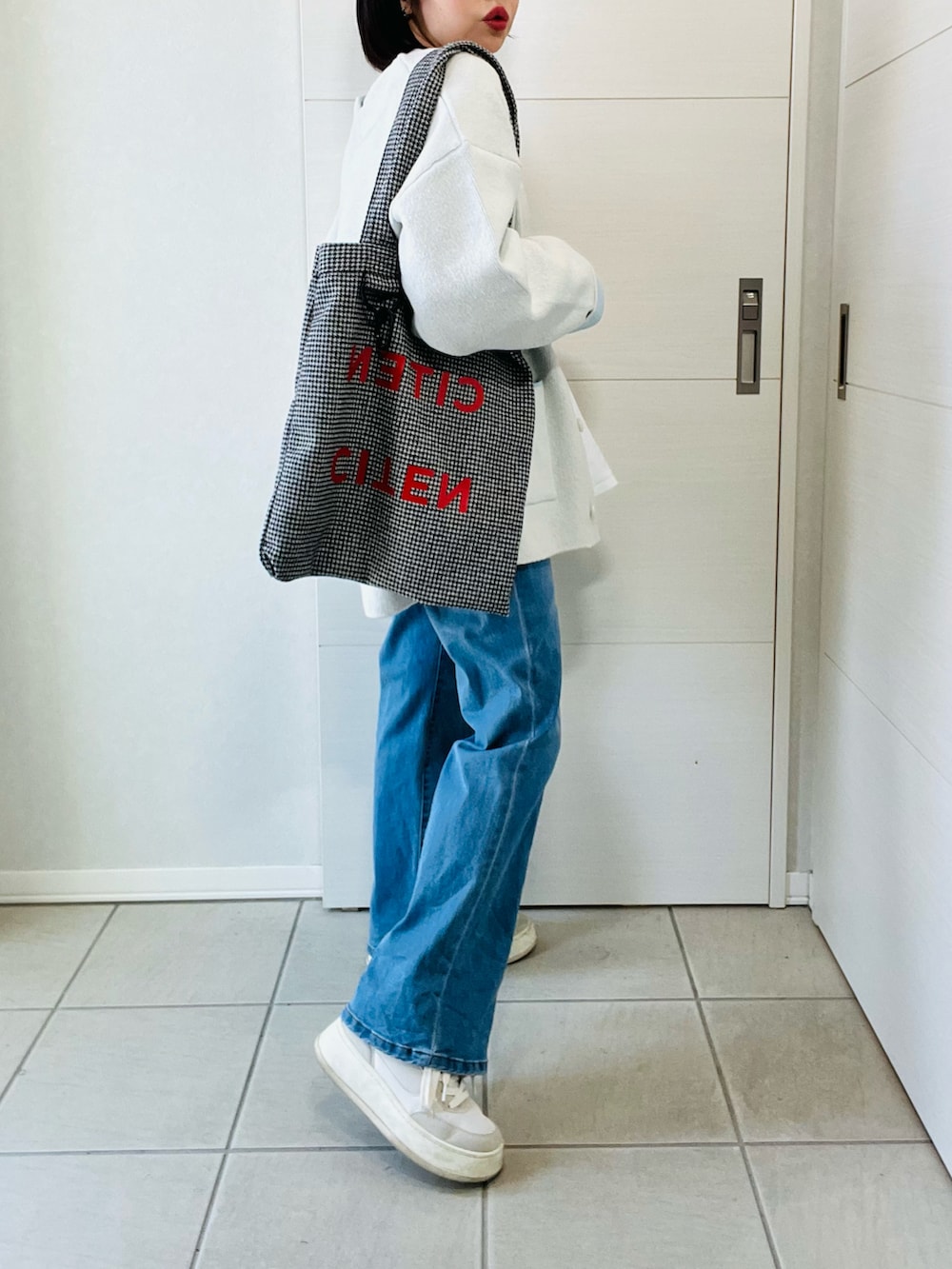 ホワイト系のカーディガン/ボレロ、ブルー系のデニムパンツ、ブラック系のトートバッグを着用したレディースの春コーディネートの5枚目の写真