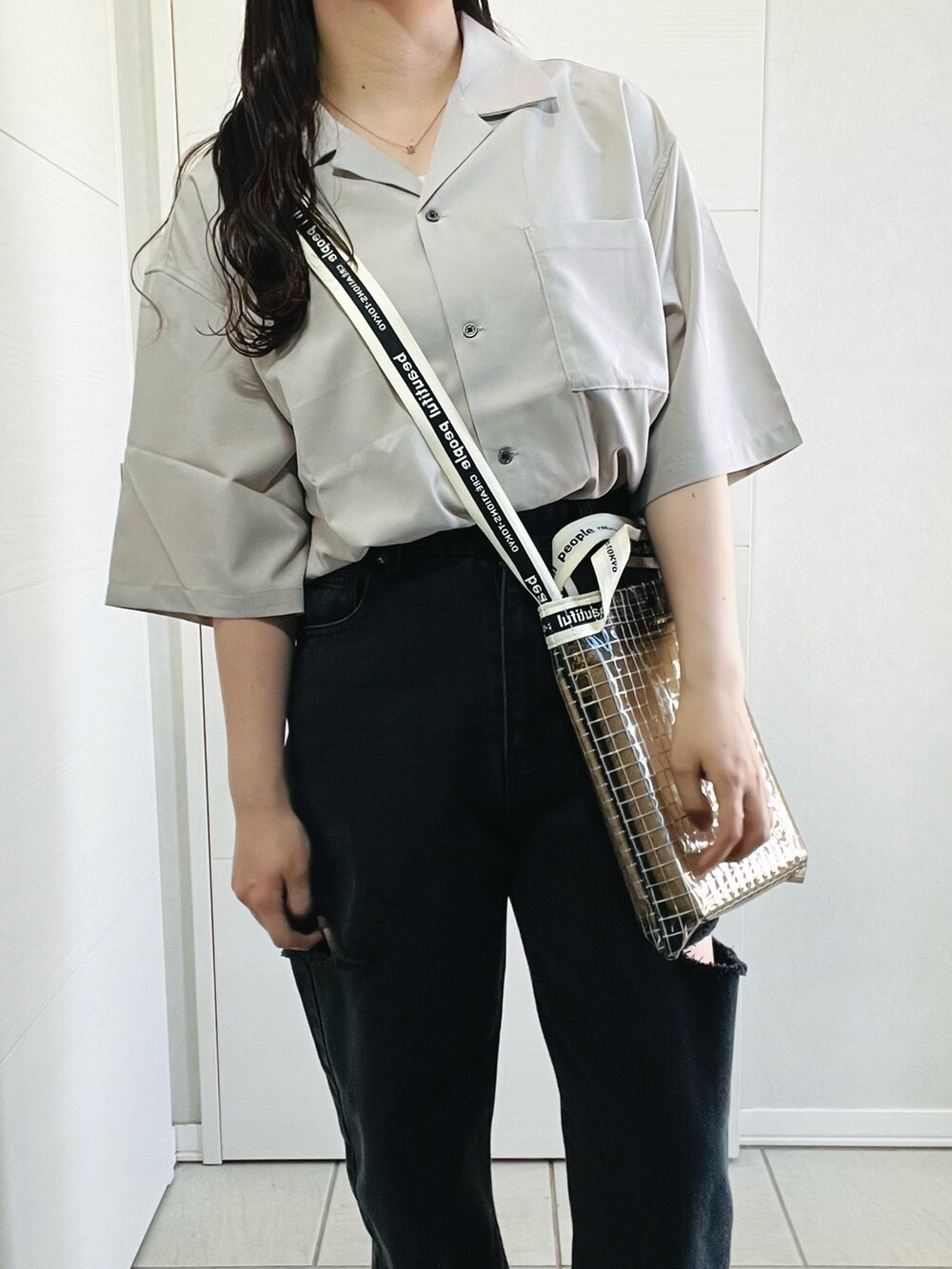 ベージュ系のシャツ/ブラウス、ブラック系のデニムパンツ、ブラック系のサンダルを着用したレディースの春コーディネートの2枚目の写真