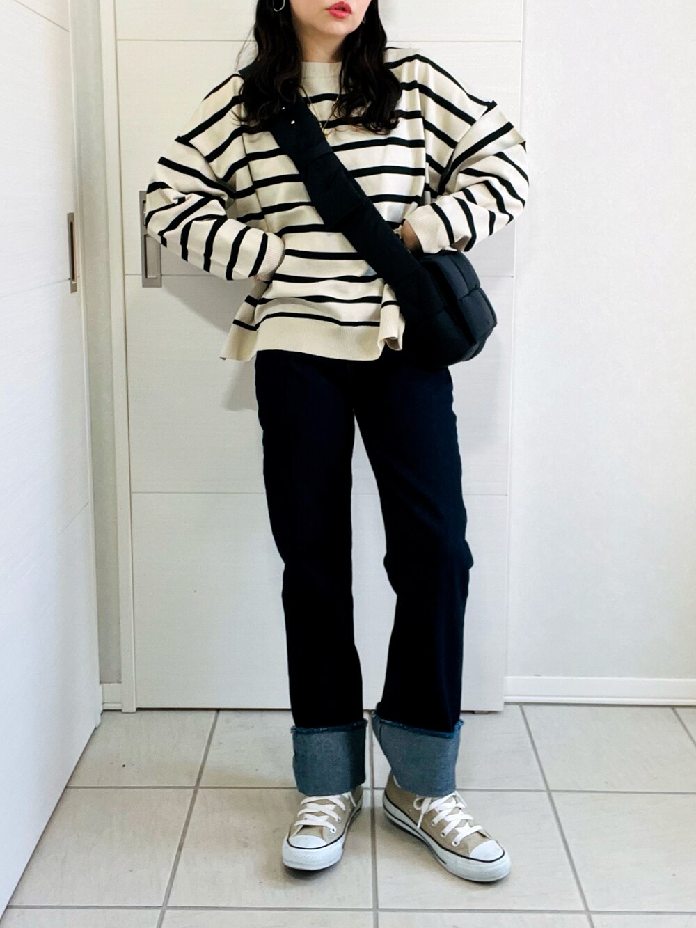 ホワイト系のニット/セーター、ブルー系のデニムパンツ、ベージュ系のスニーカーを着用したレディースの秋コーディネートの2枚目の写真