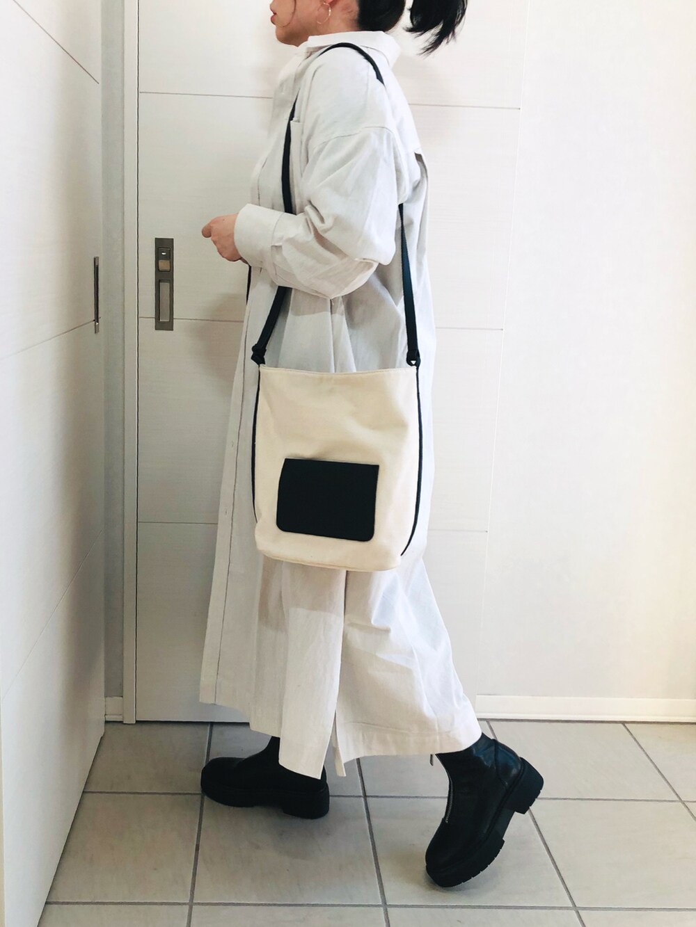 ベージュ系のワンピース、ブルー系のTシャツ/カットソー、ブラック系のジャンパースカートを着用したレディースの冬コーディネートの4枚目の写真