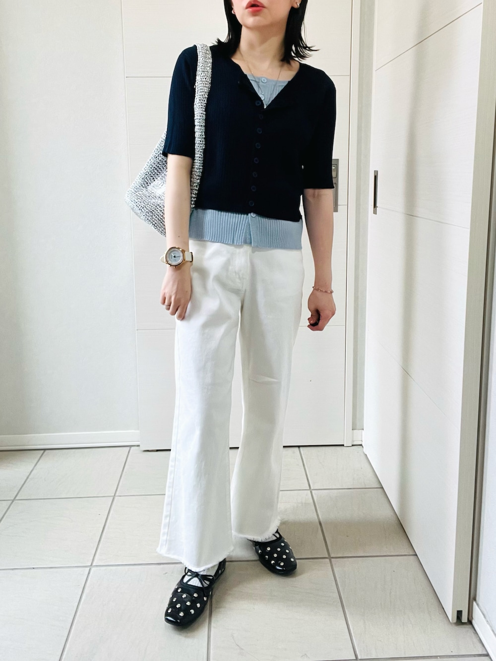 ブルー系のニット/セーター、ホワイト系のデニムパンツ、ブラック系のバレエシューズを着用したレディースの春コーディネートの4枚目の写真