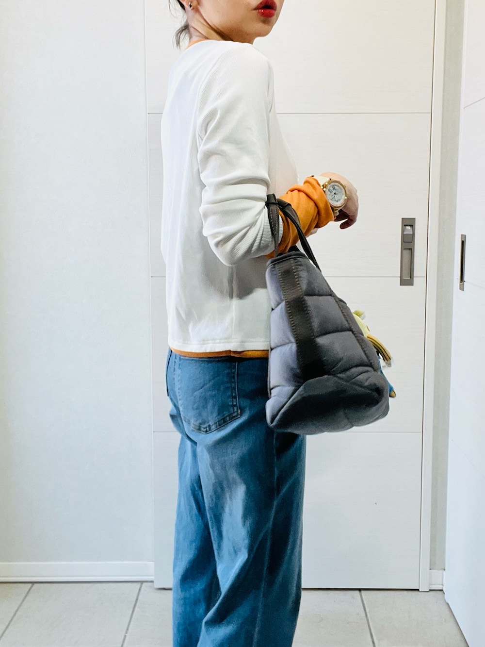 ブルー系のデニムパンツ、ホワイト系のTシャツ/カットソー、ブラック系のスニーカーを着用したレディースの春コーディネートの3枚目の写真