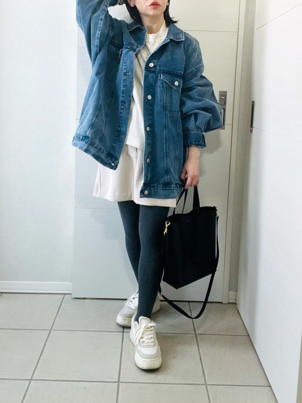 ブルー系のデニムジャケット、ベージュ系のニット/セーター、ホワイト系のスカートを着用したレディースの冬コーディネートの4枚目の写真