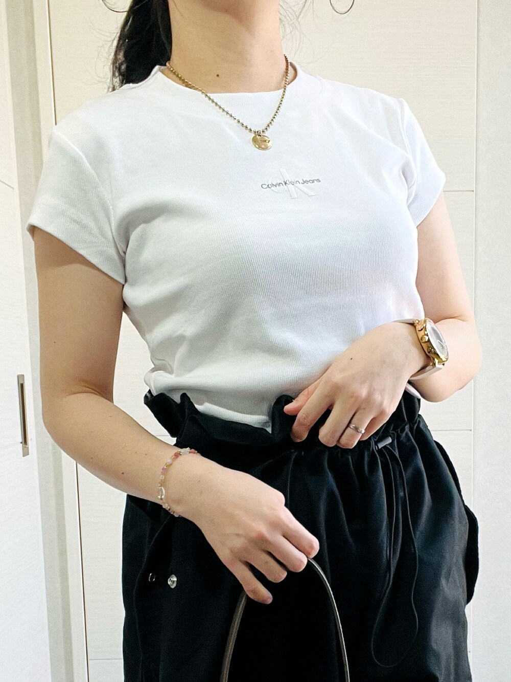 ホワイト系のTシャツ/カットソー、ブラック系のカーゴパンツ、ブラック系のパンプスを着用したレディースの春コーディネートの3枚目の写真