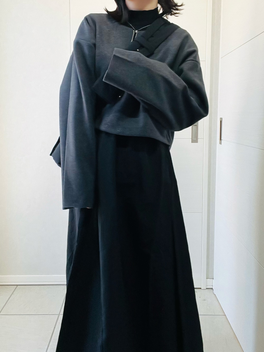 ブラック系のワンピース、ブラック系のショルダーバッグ、ブラック系のブーツを着用したレディースの秋コーディネートの2枚目の写真