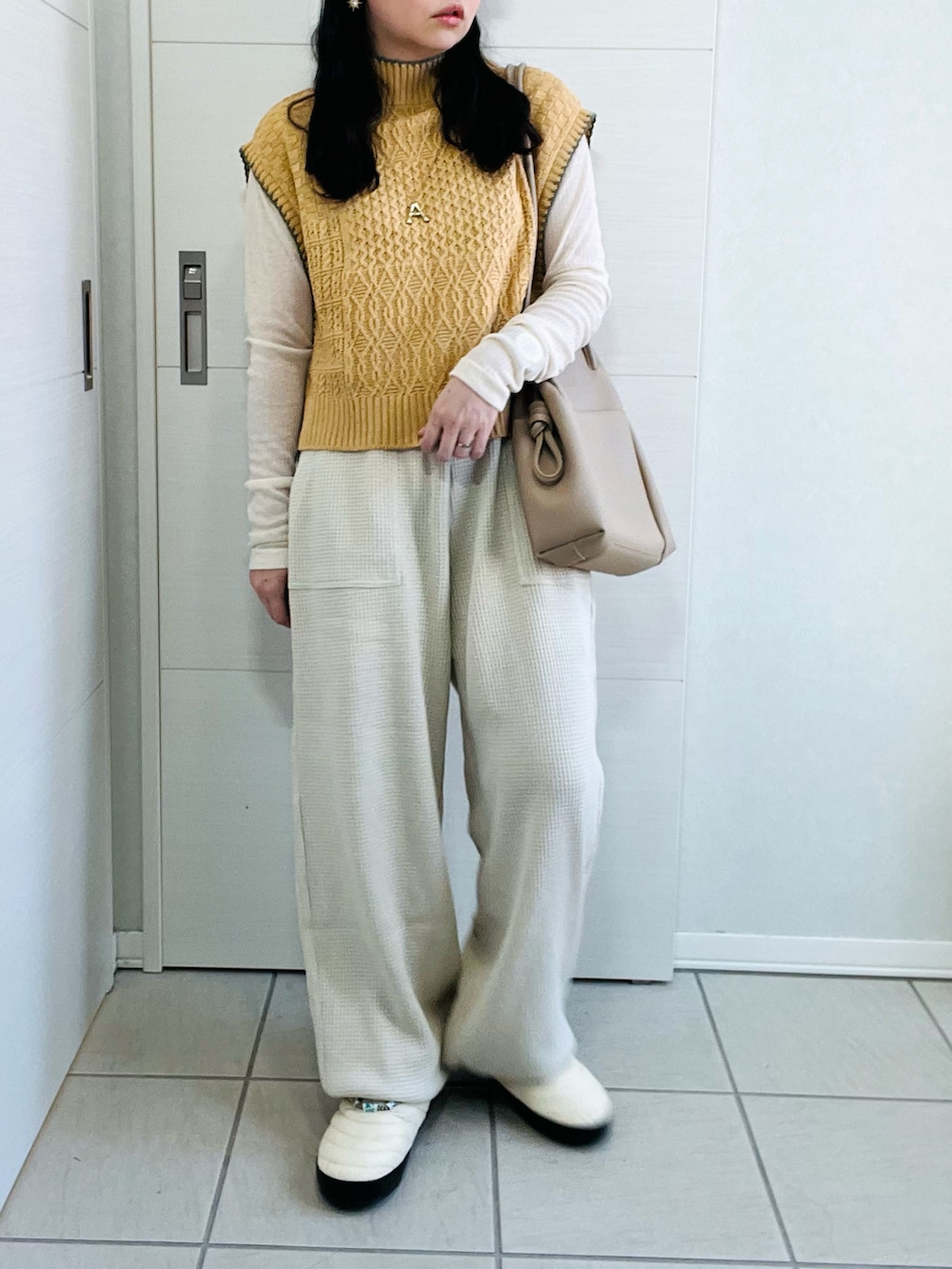 イエロー系のベスト、ホワイト系のTシャツ/カットソー、ベージュ系のその他パンツを着用したレディースの秋コーディネートの5枚目の写真