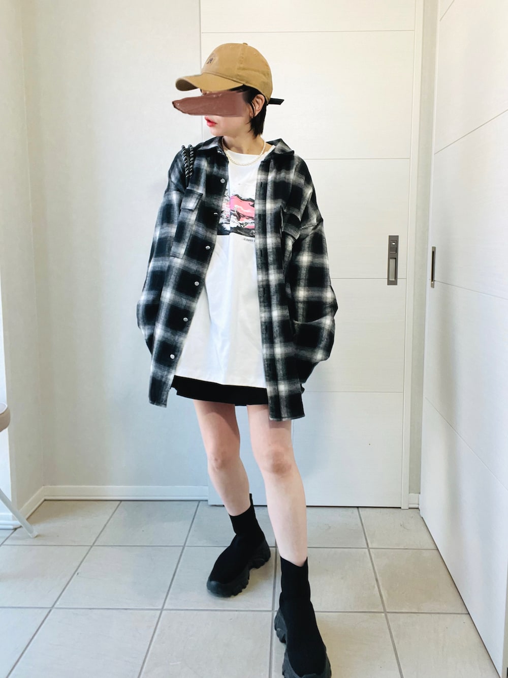 ブラック系のシャツ/ブラウス、ホワイト系のTシャツ/カットソー、ブラック系のブーツを着用したレディースの秋コーディネートの2枚目の写真