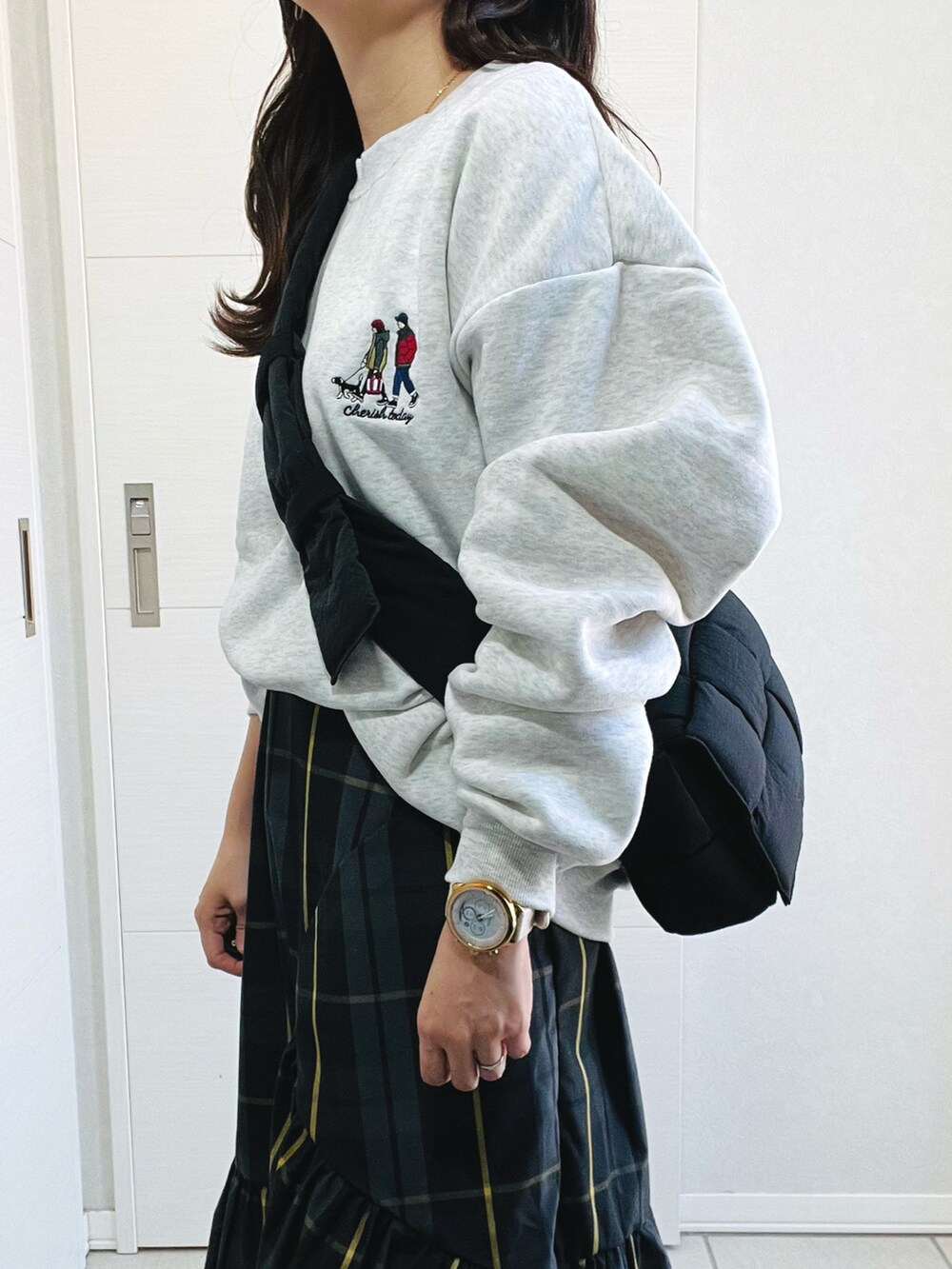 グレー系のスウェット、ブラック系のスカート、ホワイト系のスニーカーを着用したレディースの秋コーディネートの3枚目の写真