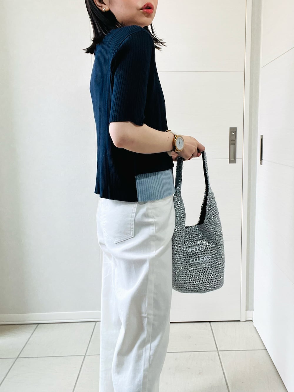 ブルー系のニット/セーター、ホワイト系のデニムパンツ、ブラック系のバレエシューズを着用したレディースの春コーディネートの3枚目の写真