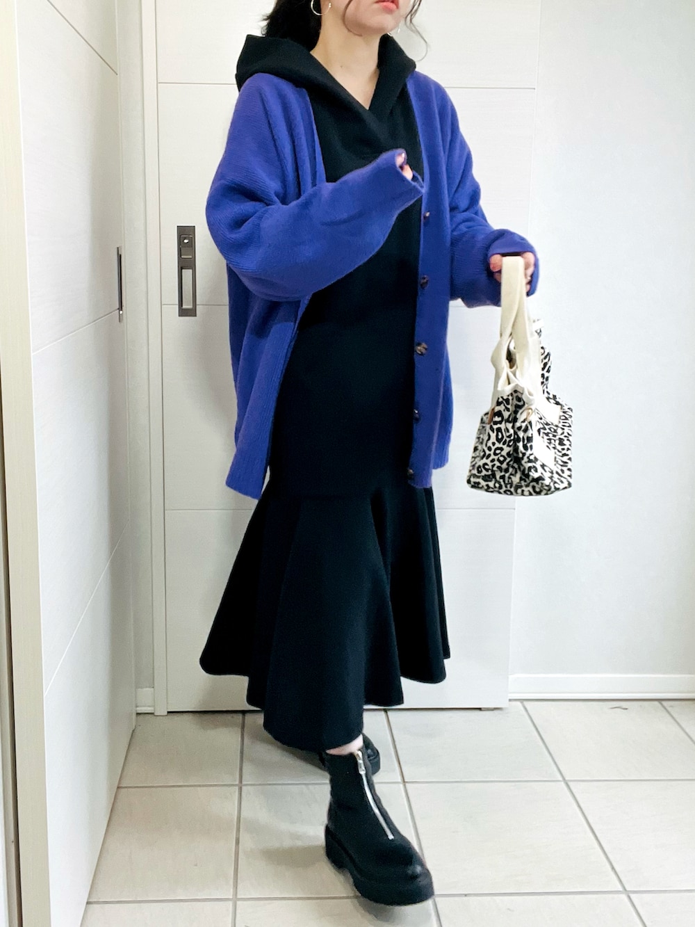 ブラック系のワンピース、パープル系のカーディガン/ボレロ、ブラック系のブーツを着用したレディースの秋コーディネートの3枚目の写真