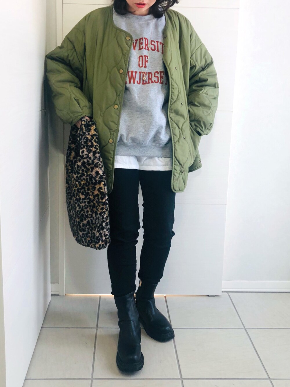 グレー系のスウェット、グリーン系のブルゾン、ブラック系のデニムパンツを着用したレディースの冬コーディネートの2枚目の写真