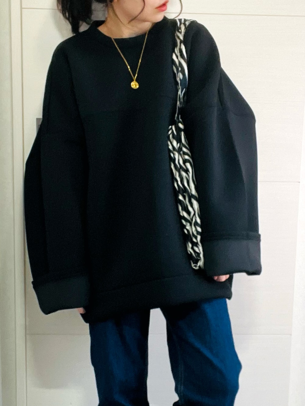 ブラック系のスウェット、ホワイト系のダウンジャケット/コート、ブルー系のデニムパンツを着用したレディースの冬コーディネートの3枚目の写真