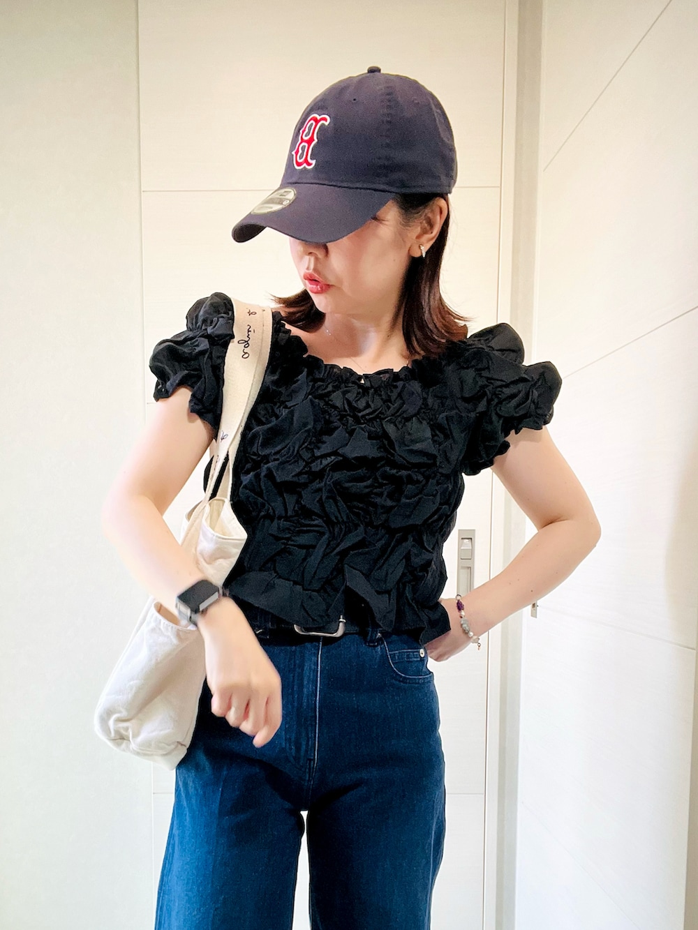 ブラック系のシャツ/ブラウス、ベージュ系のトートバッグ、グレー系のスニーカーを着用したレディースの夏コーディネートの3枚目の写真