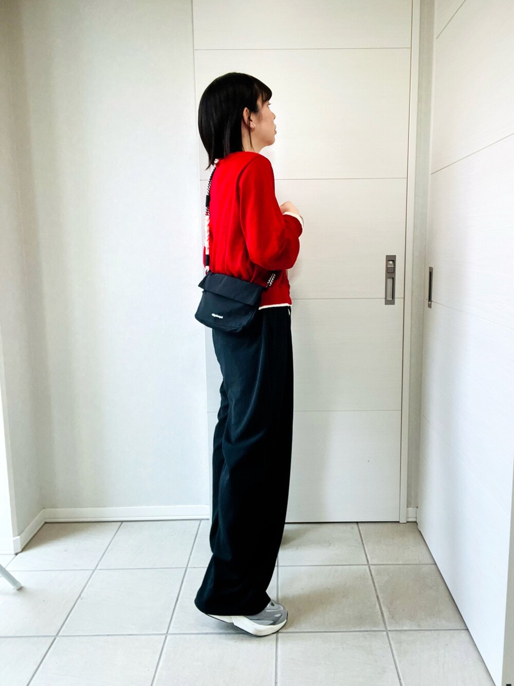 レッド系のカーディガン/ボレロ、ブラック系のその他パンツ、グレー系のスニーカーを着用したレディースの春コーディネートの3枚目の写真