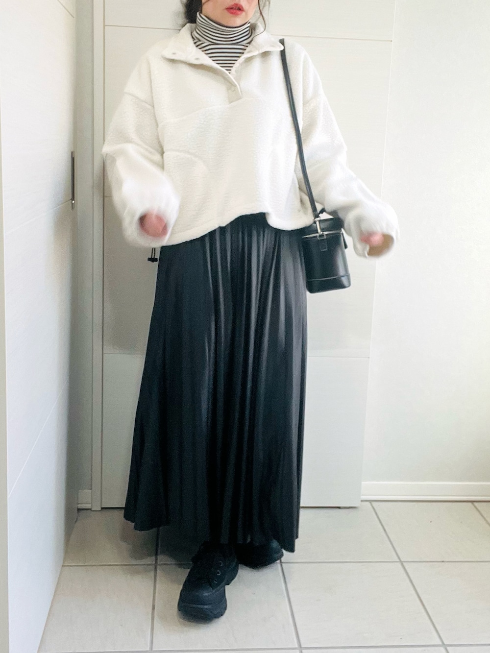 ホワイト系のTシャツ/カットソー、その他のニット/セーター、ブラック系のスカートを着用したレディースの冬コーディネートの2枚目の写真