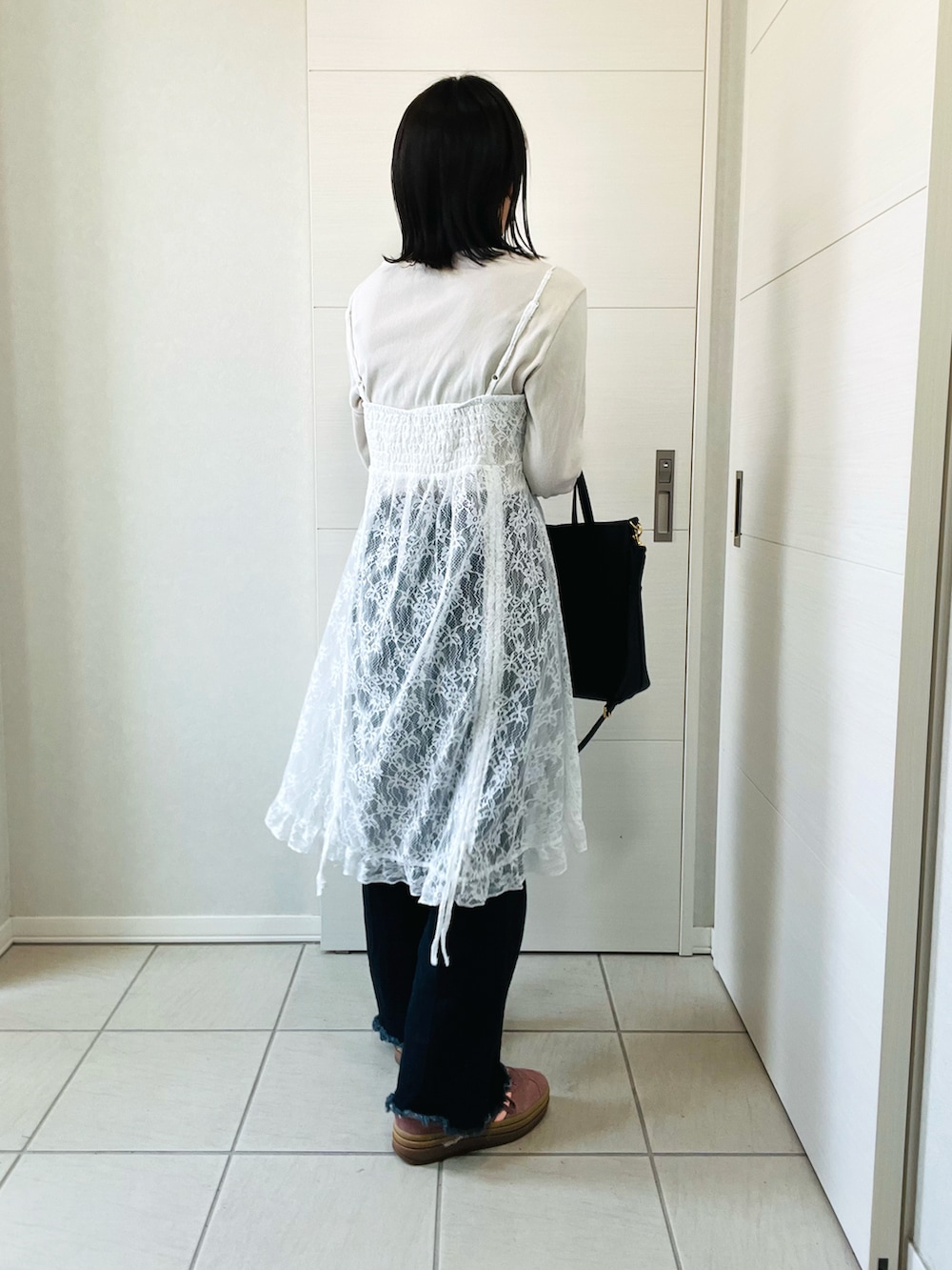 ホワイト系のチュニック、ホワイト系のTシャツ/カットソー、ブルー系のデニムパンツを着用したレディースの春コーディネートの2枚目の写真