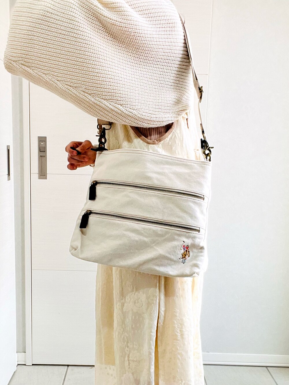 ホワイト系のショルダーバッグ、ホワイト系のカーディガン/ボレロ、ホワイト系のワンピースを着用したレディースの春コーディネートの2枚目の写真