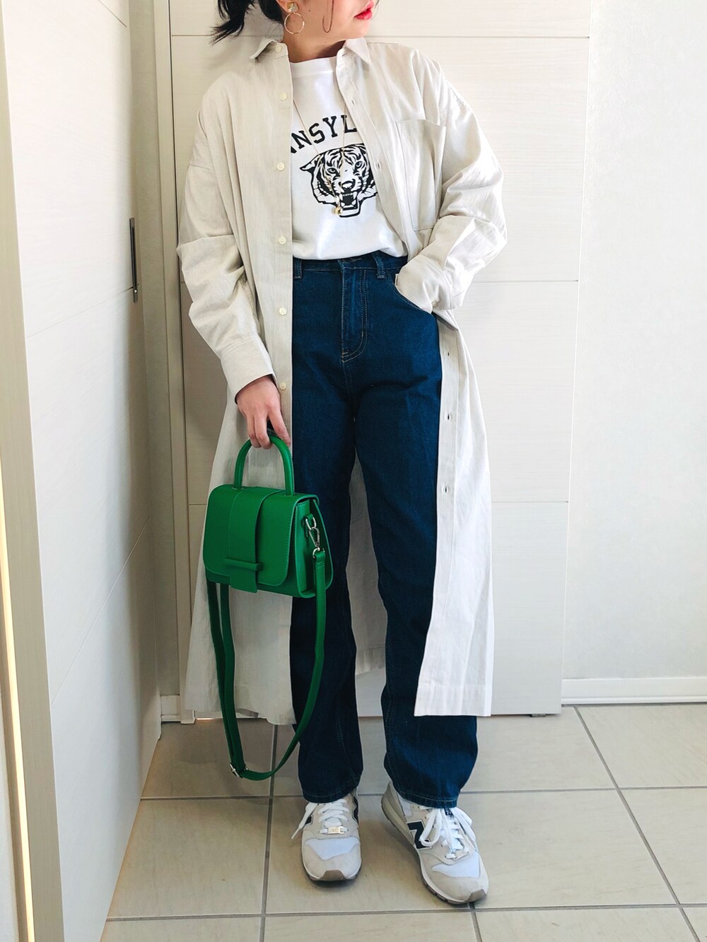 ベージュ系のワンピース、ホワイト系のTシャツ/カットソー、ブルー系のデニムパンツを着用したレディースの冬コーディネートの2枚目の写真