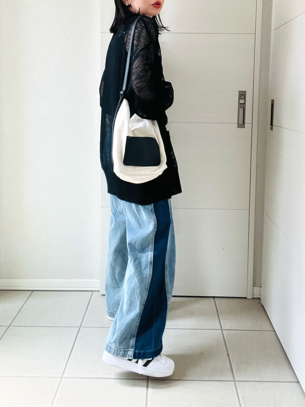 ブラック系のカーディガン/ボレロ、ブルー系のデニムパンツ、ホワイト系のスニーカーを着用したレディースの夏コーディネートの5枚目の写真