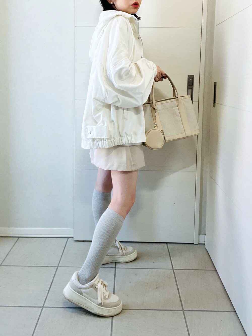 ホワイト系のマウンテンパーカー、ブルー系のTシャツ/カットソー、ホワイト系のスカートを着用したレディースの春コーディネートの5枚目の写真