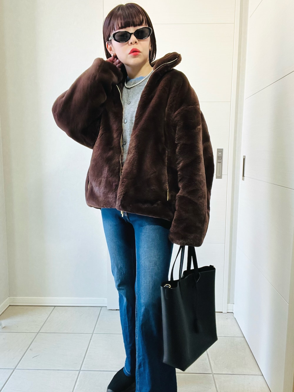 ブラウン系のジャケット/アウター、ブルー系のデニムパンツ、ブラック系のブーツを着用したレディースの冬コーディネートの3枚目の写真