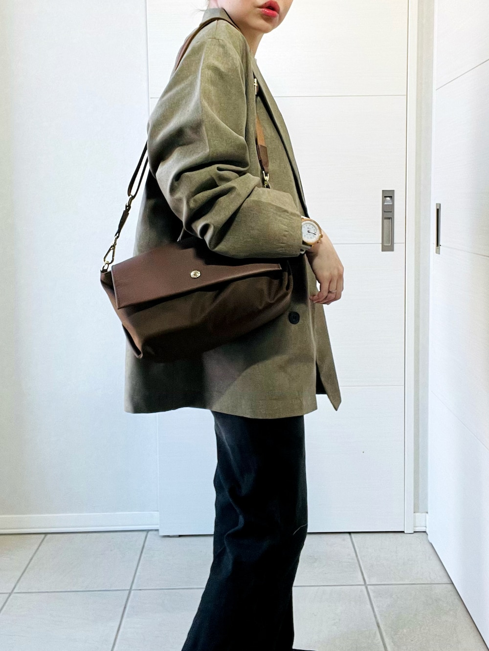 ベージュ系のテーラードジャケット、ベージュ系のスウェット、ブラック系のデニムパンツを着用したレディースの春コーディネートの3枚目の写真