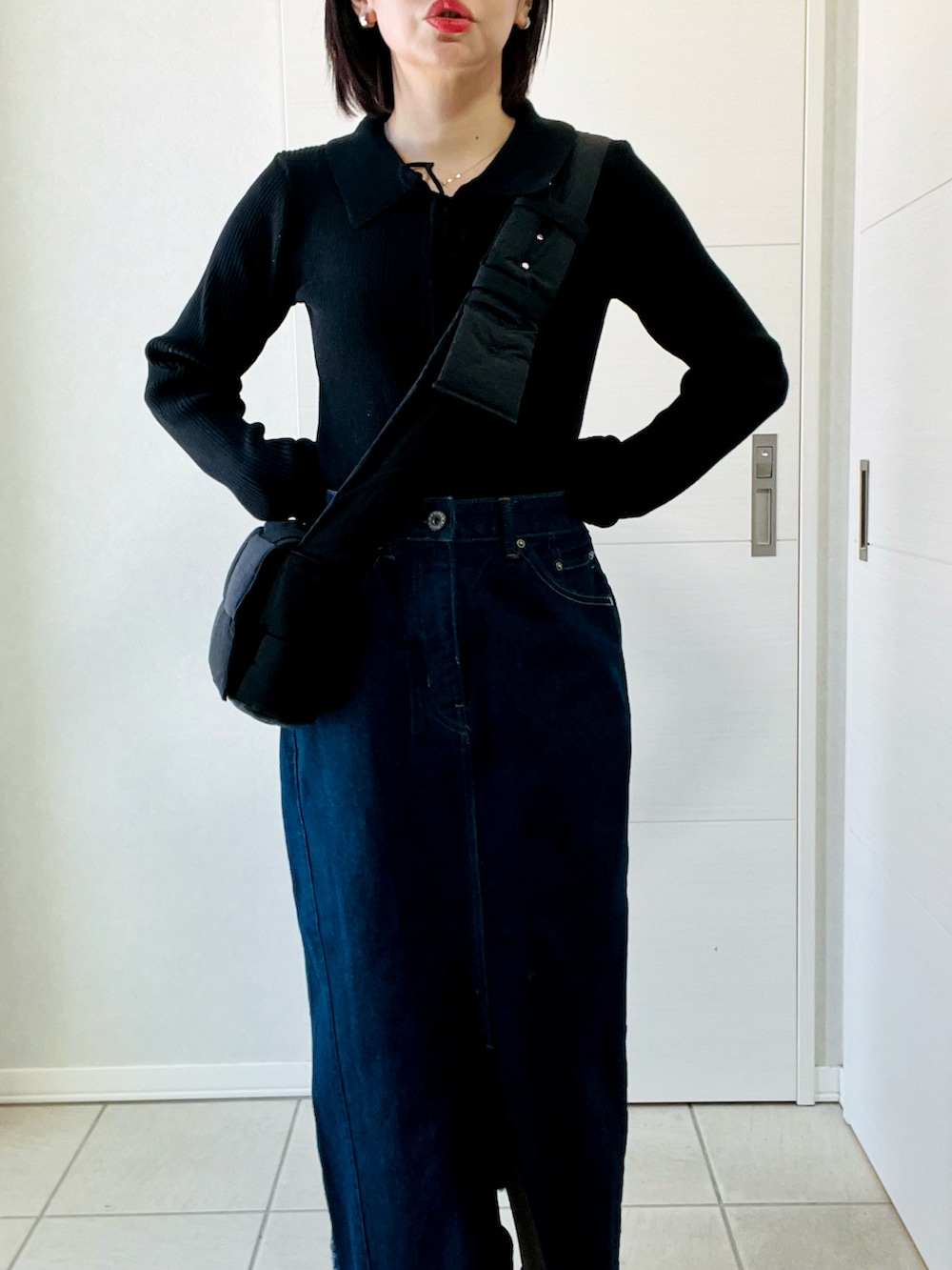 ブラック系のニット/セーター、ブルー系のスカート、ブラック系のブーツを着用したレディースの冬コーディネートの2枚目の写真